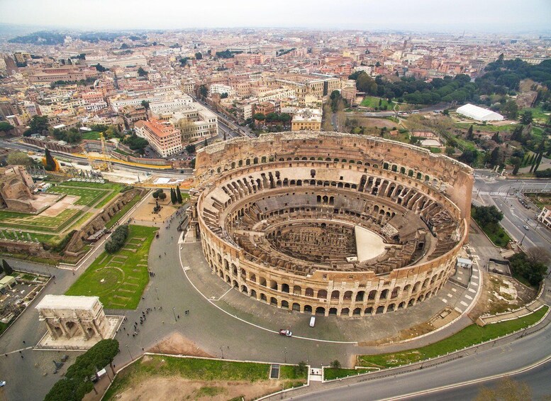 The Colosseum surrounded by city buildings and roads. 5