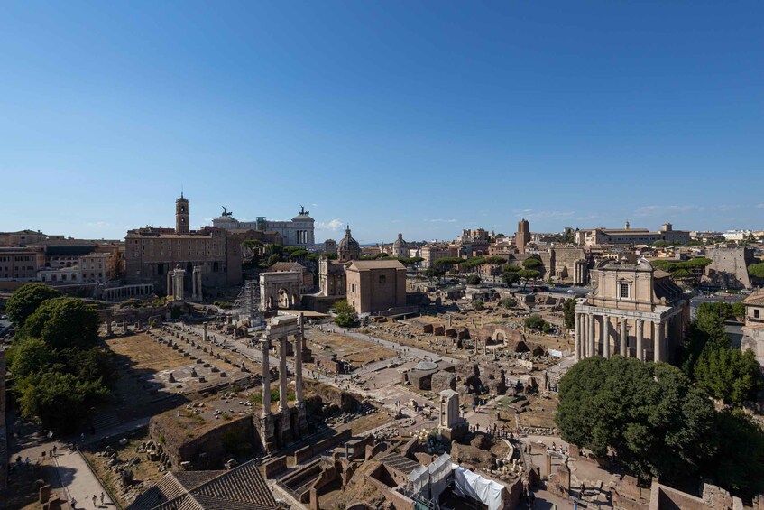 An ancient Roman cityscape with ruins, including columns, temples, and a large open square. 2