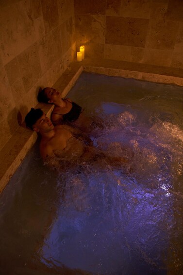Two people in a hot tub with water jets. 3