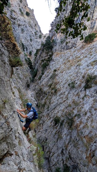 A person rappelling down a steep, rocky cliff. 2