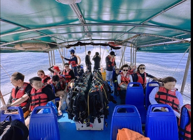 A boat with passengers wearing life jackets, equipped with scuba gear, and a canopy overhead. 2