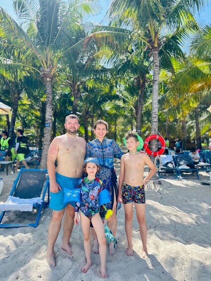 A family on a sandy beach with palm trees and beach chairs. 2