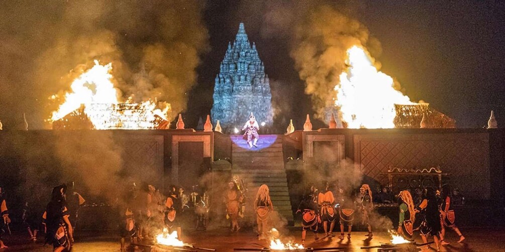 A nighttime outdoor performance with fire effects and a central stage. 3
