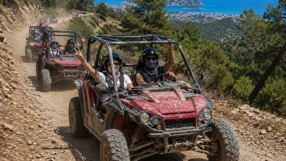 Off-road vehicles on a dirt trail with a coastal landscape in the background. 5