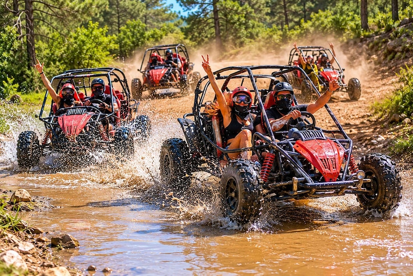 Off-road vehicles crossing a shallow water stream in a forested area. 2