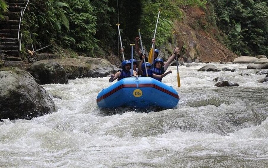 A group of people rafting down a river with rapids. 1