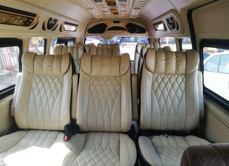 The interior of a vehicle with three beige leather seats, a sunroof, and a decorative ceiling. 5