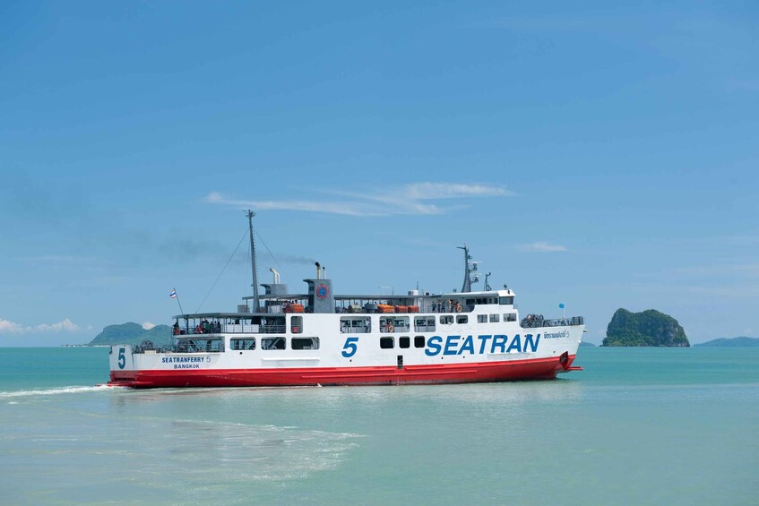 A ferry named SEATRAN 5 traveling on clear blue waters. 1