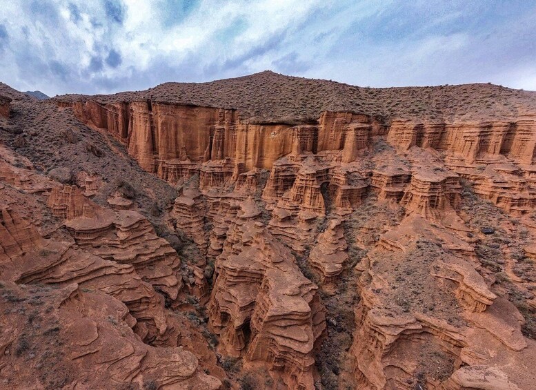 A canyon with layered rock formations and a mountain in the background. 4