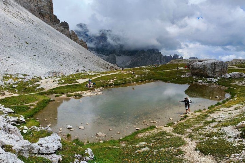 A mountain lake with rocky terrain and a person standing by the water. 2