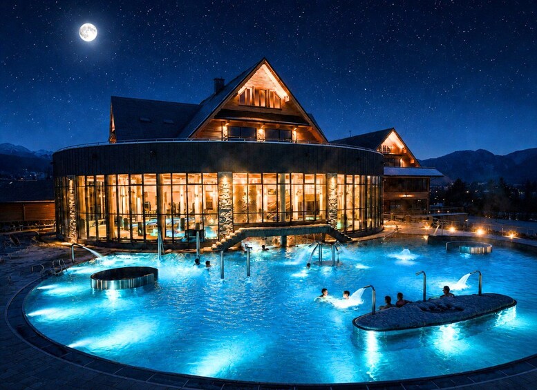 A resort with a large swimming pool, a wooden building, and a night sky with stars. 3