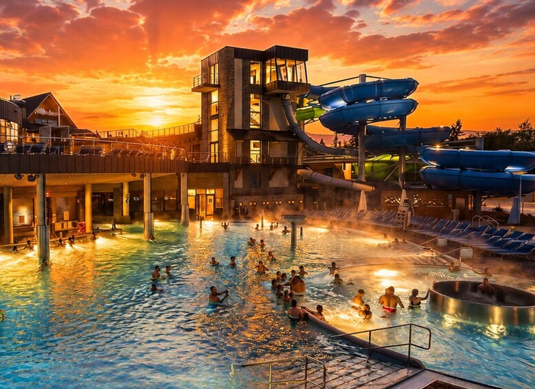 A water park with a large pool, a water slide, and a building with multiple levels. 5