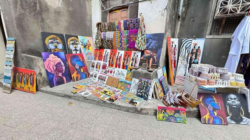 A street art display with paintings and textiles. 3