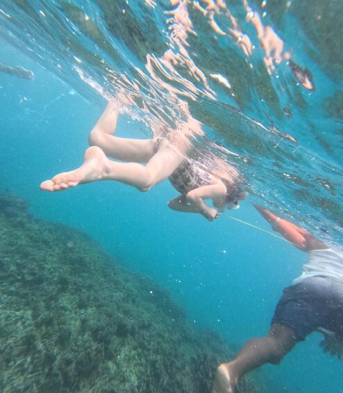 Two people swimming underwater in clear blue water. 5