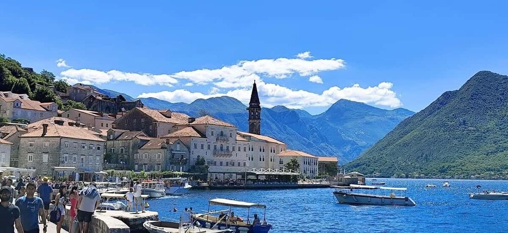 A coastal town with historic buildings, a church, and boats on the water. 5