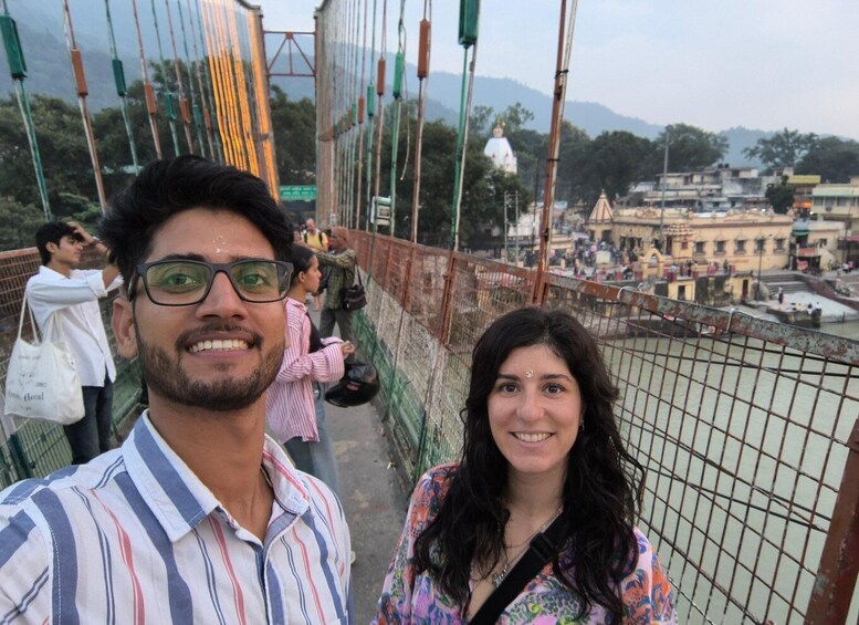 A pedestrian bridge with a view of a temple and cityscape in the background. 3