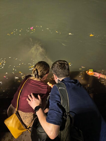 Two people observing a body of water with floating objects. 4