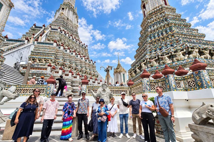 A group of people standing in front of a large, intricately decorated temple with multiple spires and statues. 2