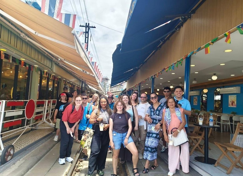 A group of people on a cruise ship deck with a restaurant and outdoor seating area. 4
