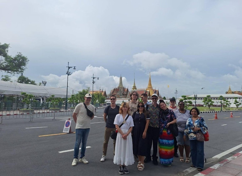 A group of people posing in front of a temple with golden spires. 5