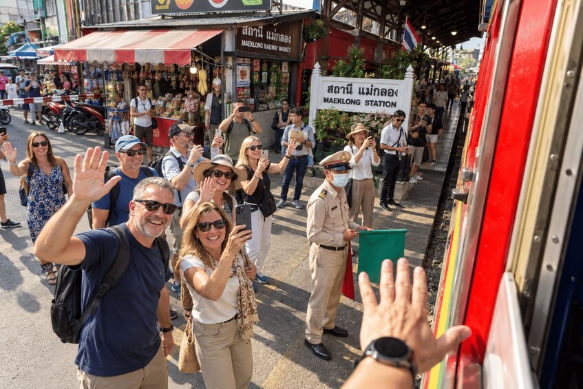 A group of people taking a photo with a bus. 4