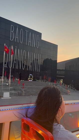 A large building with the sign 'BAO TANG QUANG NINH' and red flags in front. 5