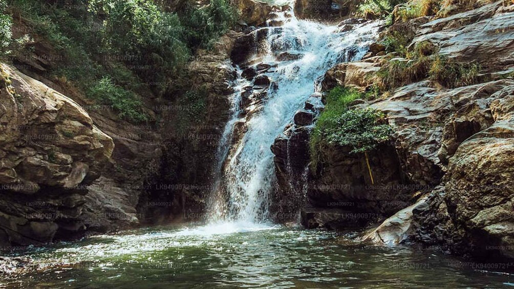 A waterfall cascading down a rocky cliff into a pool below. 3