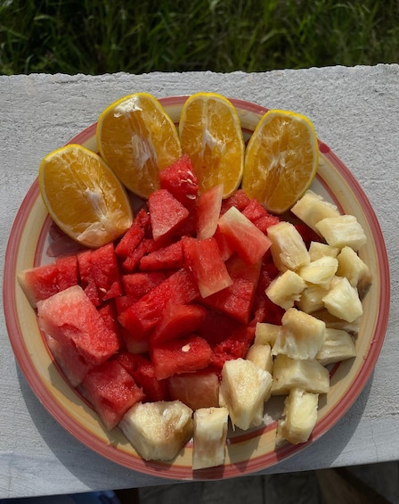 A plate with watermelon, pineapple, and orange slices on a table. 5