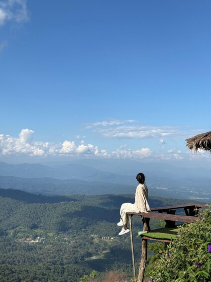 A person sitting on a bench overlooking a mountainous landscape. 1
