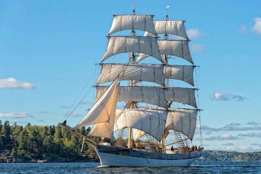 A tall ship with multiple sails sailing on the water. 1