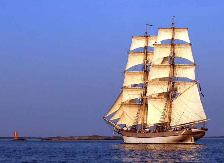 A tall ship with multiple sails sailing on calm waters. 5