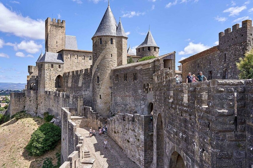 A medieval castle with stone walls, towers, and a courtyard. 1