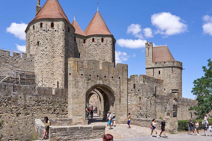 A historic stone castle with multiple towers and a central archway. 4