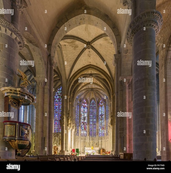 A cathedral interior with Gothic architecture, stained glass windows, and a large altar. 2