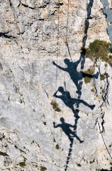 A rocky cliff with a shadow of a person climbing. 2