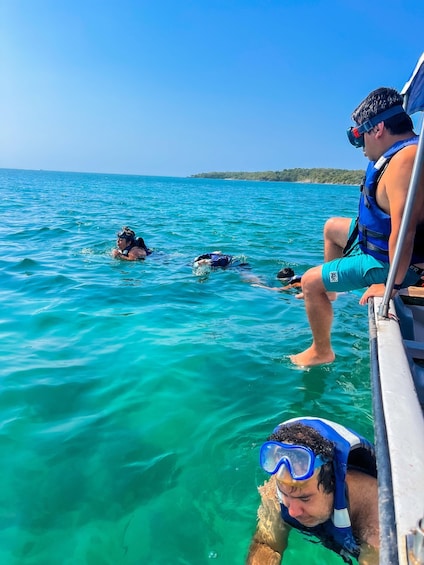 A group of people snorkeling in clear turquoise waters. 2