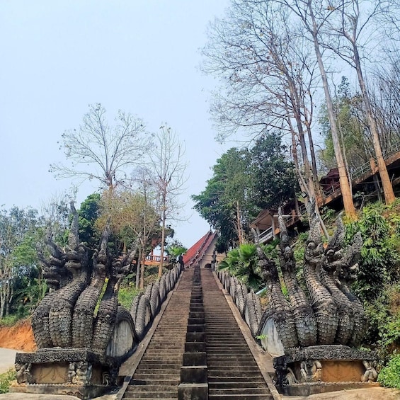 A staircase leading up to a temple with ornate dragon sculptures on either side. 3