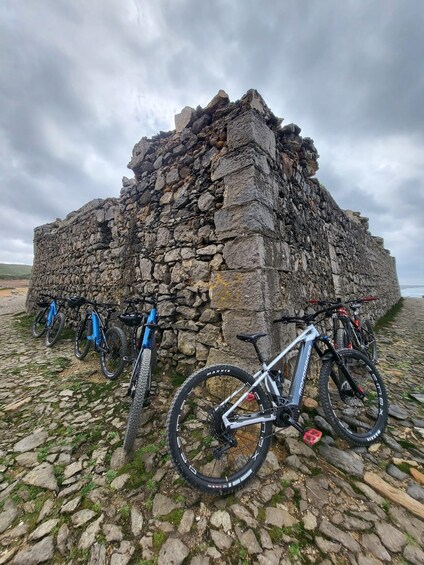 A stone structure with bicycles parked in front. 2