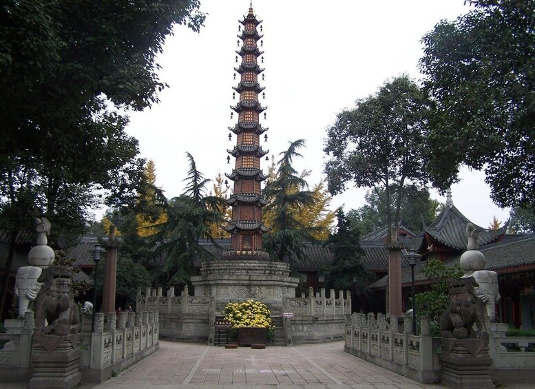 Una pagoda tradicional de varios niveles, rodeada por estatuas de leones de piedra y un jardín cuidado. 3