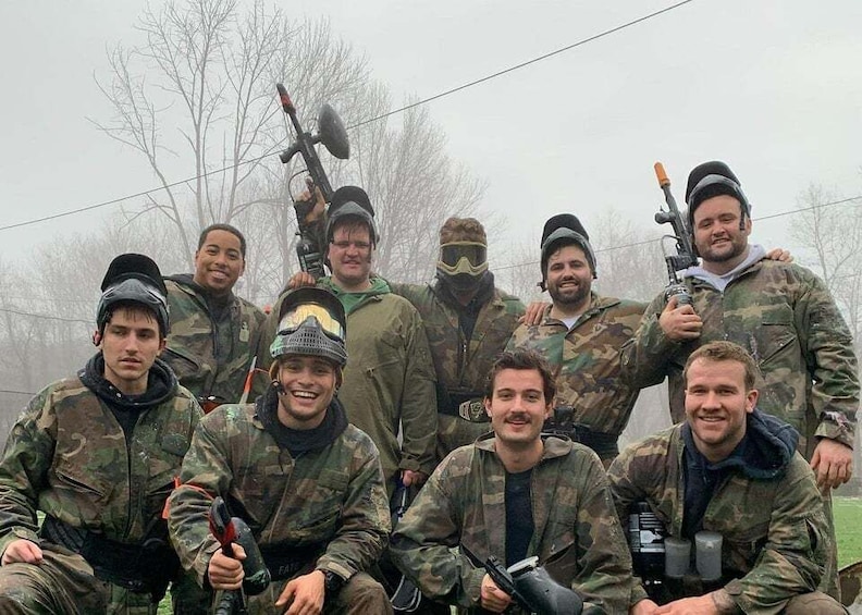 A group of people in military camouflage attire, some holding firearms, standing in a foggy outdoor setting. 3