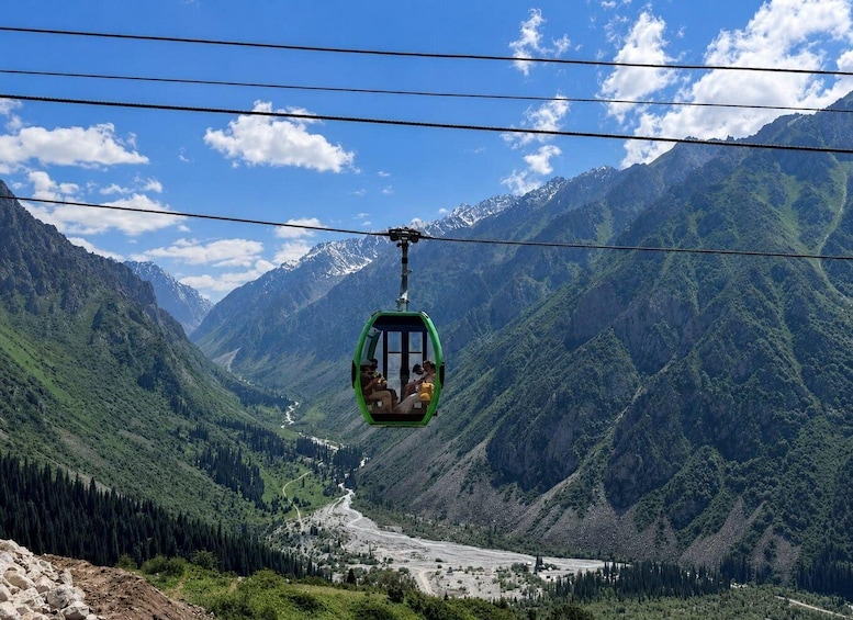 A cable car suspended over a mountainous landscape with a valley below. 1