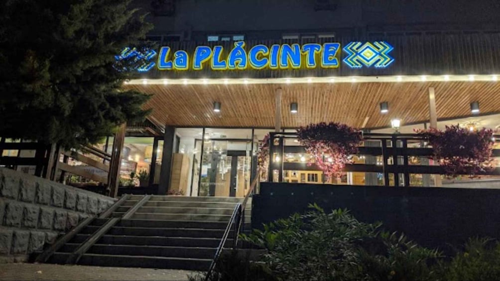 A building with a sign reading 'La Placinte' at night. 4