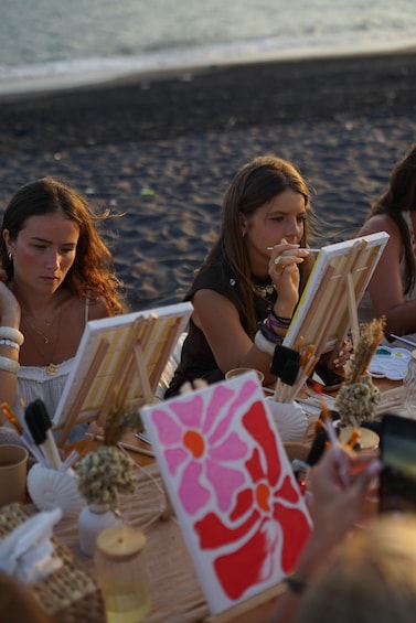 People painting on easels by the beach. 2