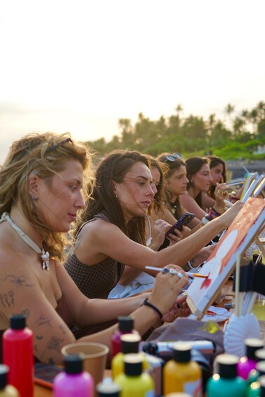 A group of people painting on easels outdoors. 5