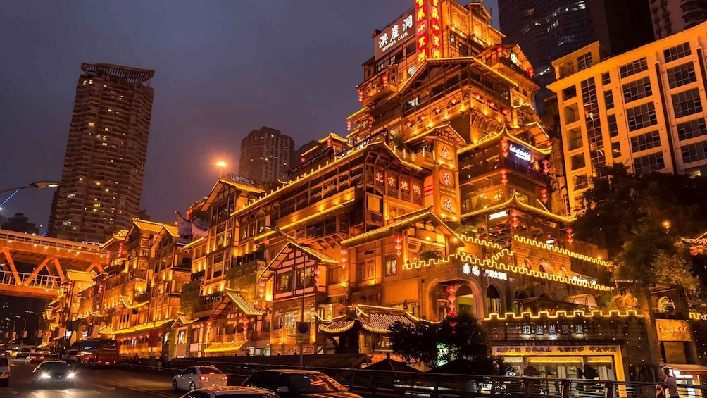 A brightly lit traditional building with ornate architecture and signage in a cityscape at night. 3
