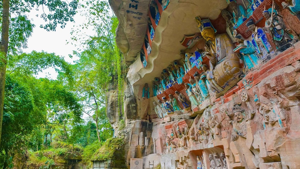 A rock face with numerous colorful statues and carvings. 5