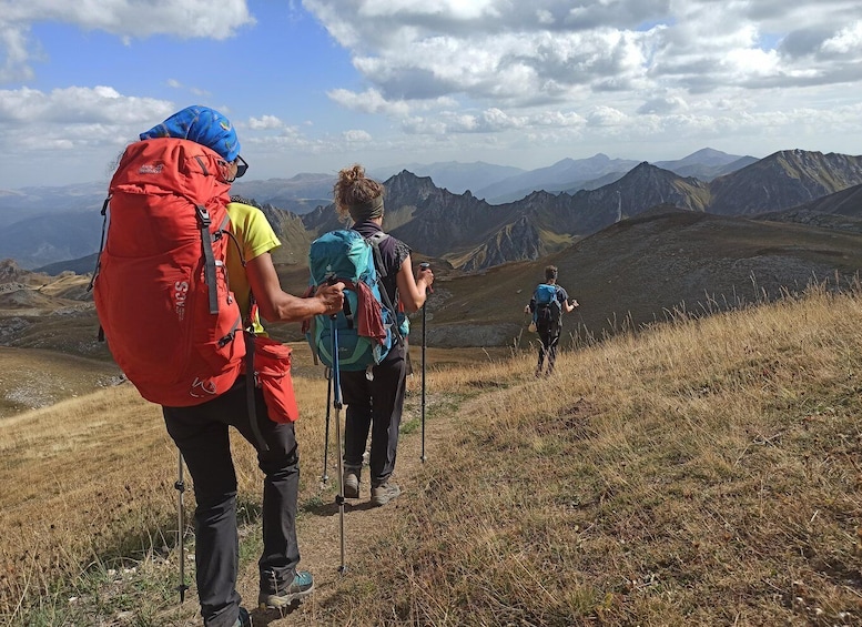 Hikers on a mountain trail with a clear sky and distant mountains. 4