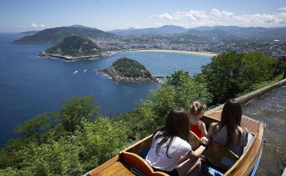 A boat tour with passengers overlooking a coastal town and islands. 1