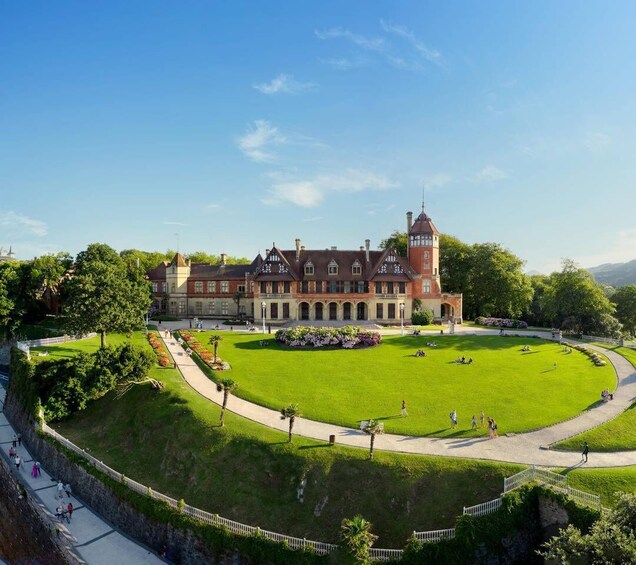 A large historic building with a central lawn and a tower. 3