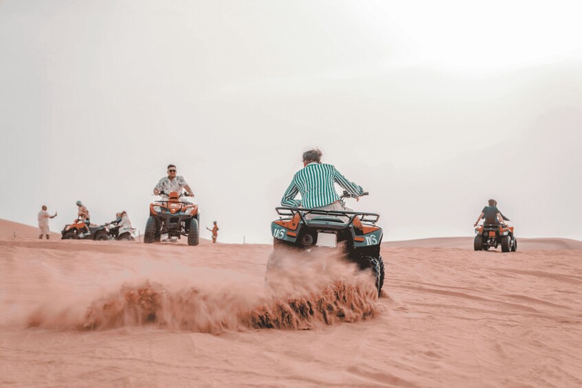 A group of people on ATVs in a desert with sand dunes. 5
